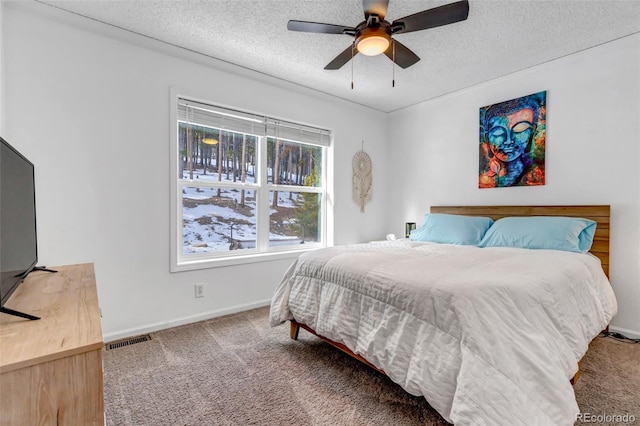 bedroom with visible vents, a ceiling fan, a textured ceiling, carpet flooring, and baseboards