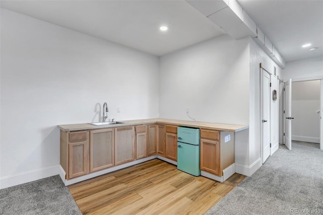 kitchen with light wood-type flooring, recessed lighting, baseboards, and a sink