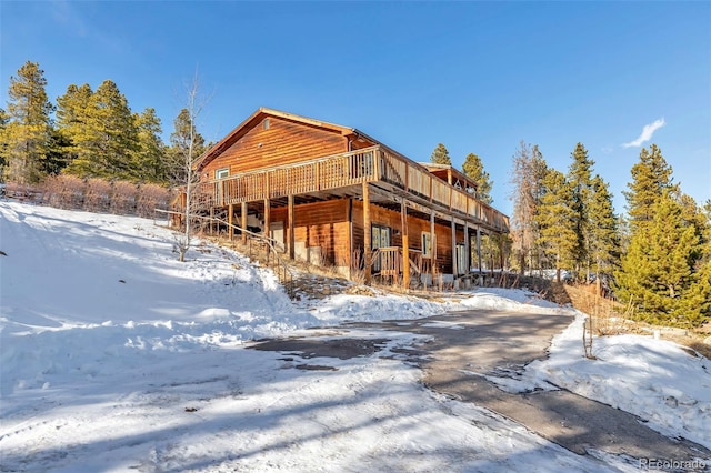 view of snowy exterior featuring a wooden deck