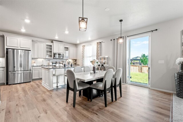 3074 Kestrel St, Brighton, CO 80601 - dining room with light wood-style floors and recessed lighting