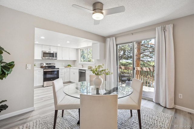 dining space featuring light wood-style floors, baseboards, ceiling fan, a textured ceiling, and recessed lighting