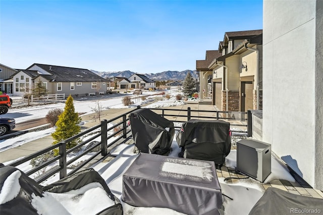 snow covered back of property featuring a mountain view