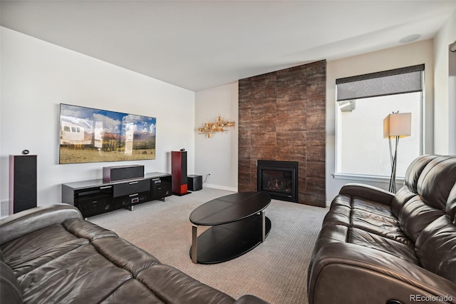 carpeted living room with a tile fireplace