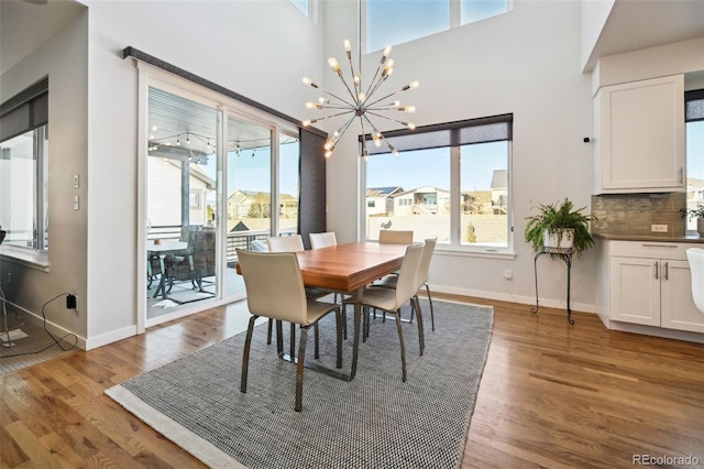 dining space with hardwood / wood-style floors and a notable chandelier