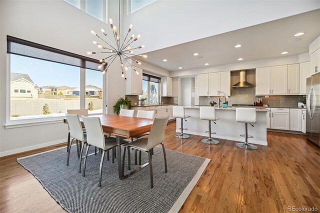 dining area with light hardwood / wood-style floors and an inviting chandelier