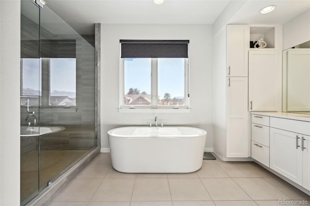 bathroom with tile patterned flooring, vanity, and separate shower and tub