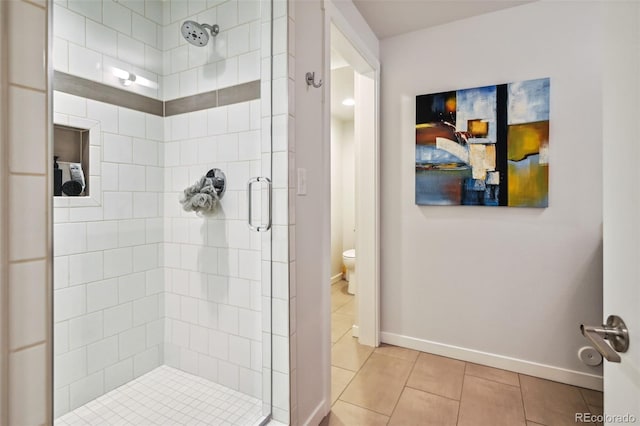 bathroom with toilet, tile patterned floors, and walk in shower