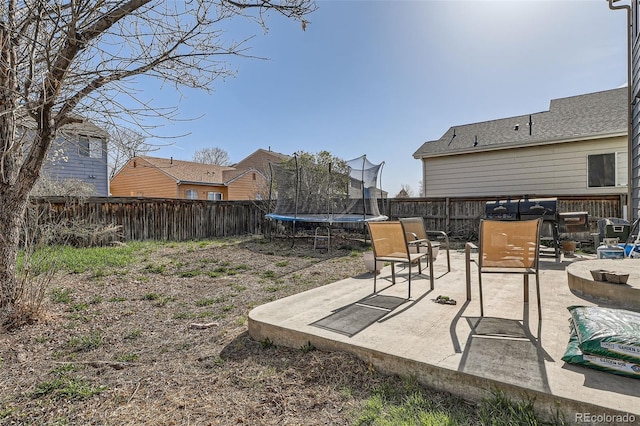 9615 Lansing Cir, Commerce City, CO 80022 - view of yard featuring a patio area, a fenced backyard, an outdoor fire pit, and a trampoline