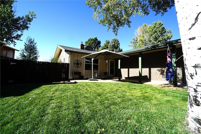 rear view of property featuring a patio area and a yard