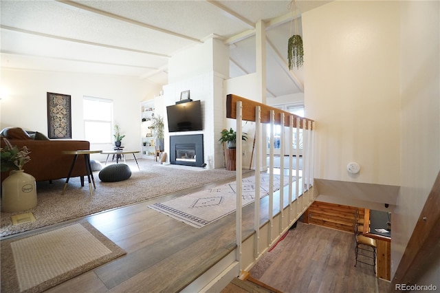 living room featuring lofted ceiling with beams and wood-type flooring