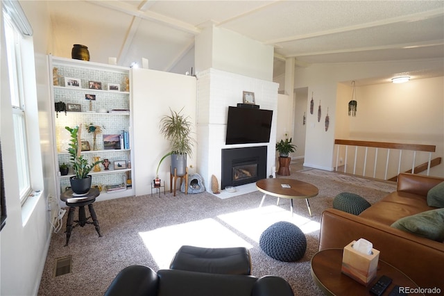 carpeted living room featuring lofted ceiling with beams