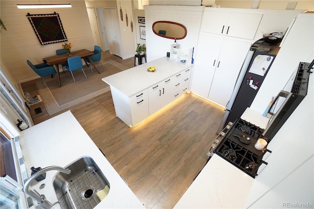 kitchen featuring white cabinets, kitchen peninsula, dark wood-type flooring, and sink