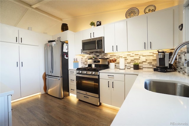 kitchen featuring white cabinetry, sink, dark hardwood / wood-style floors, decorative backsplash, and appliances with stainless steel finishes