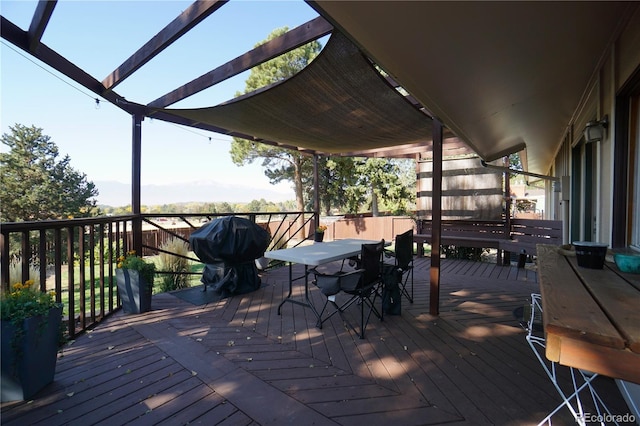 wooden deck with area for grilling and a pergola