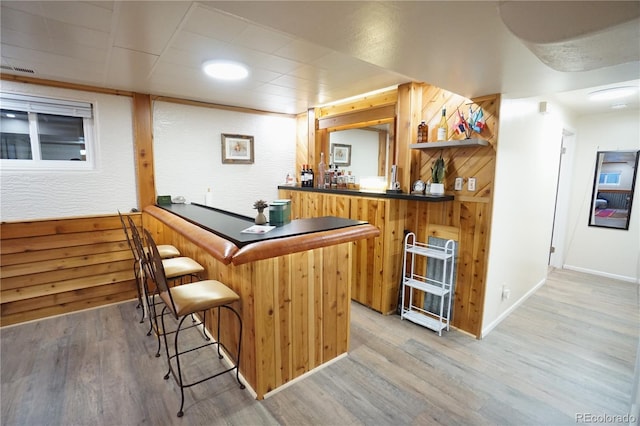 bar with wood walls and hardwood / wood-style floors