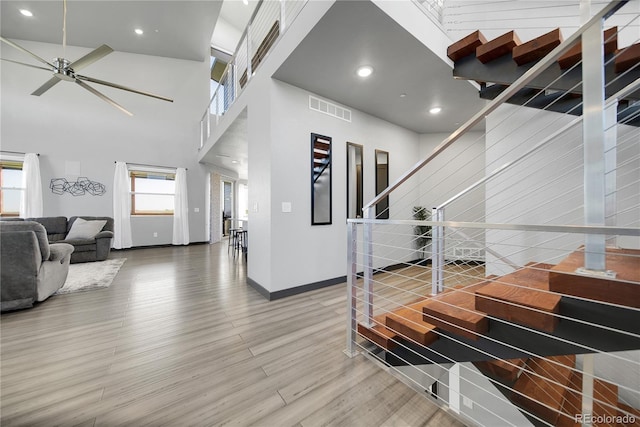 11680 Imboden Rd, Hudson, CO 80642 - stairs featuring wood finished floors, a ceiling fan, a high ceiling, and recessed lighting