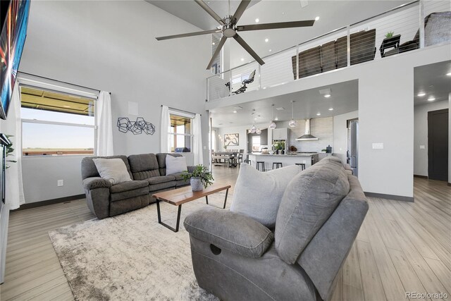 11680 Imboden Rd, Hudson, CO 80642 - living room featuring a ceiling fan, light wood-style flooring, a high ceiling, and recessed lighting