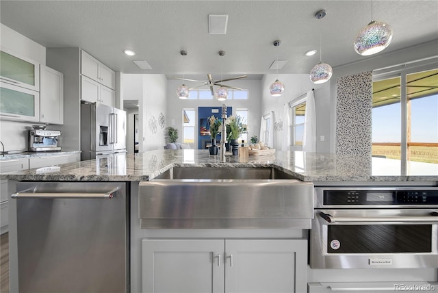11680 Imboden Rd, Hudson, CO 80642 - kitchen featuring stainless steel appliances, white cabinets, decorative light fixtures, light stone countertops, and recessed lighting