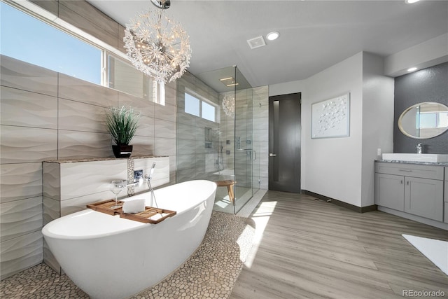 11680 Imboden Rd, Hudson, CO 80642 - bathroom with a stall shower, vanity, a freestanding tub, a chandelier, and wood finished floors