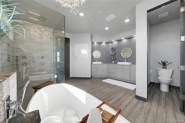 11680 Imboden Rd, Hudson, CO 80642 - bathroom with wood finished floors, double vanity, a stall shower, a freestanding bath, and recessed lighting