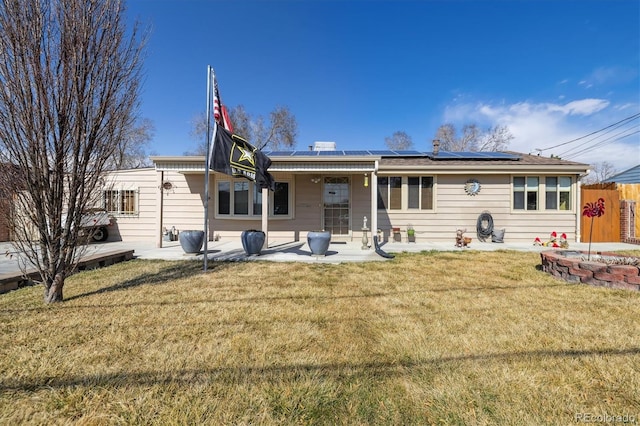 back of house with a patio area, solar panels, a yard, and fence