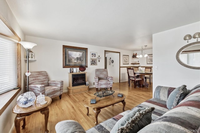 living room with baseboards, wood finished floors, and a fireplace