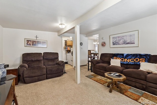 living area featuring washer / clothes dryer and light colored carpet