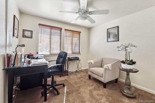 carpeted office space featuring baseboards and a ceiling fan