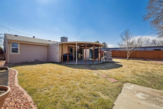 back of house with a patio, fence private yard, and a lawn