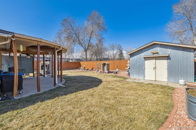 view of yard featuring ceiling fan, a patio, an outbuilding, and a fenced backyard