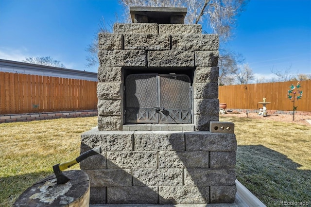 exterior space with an outdoor stone fireplace and fence