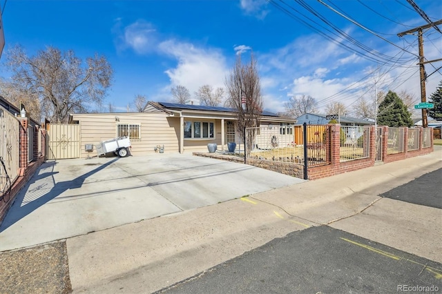 view of front facade featuring a fenced front yard and roof mounted solar panels