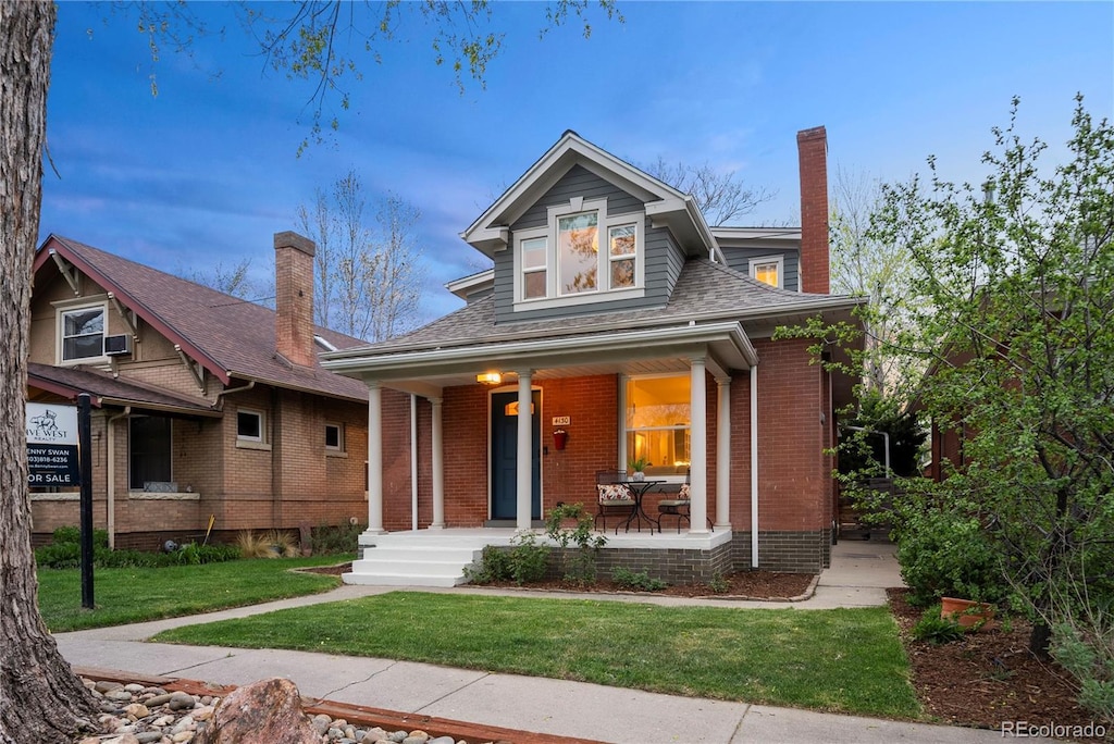 4130 Umatilla St, Denver, CO 80211 - bungalow-style home with brick siding, a front lawn, covered porch, and a chimney