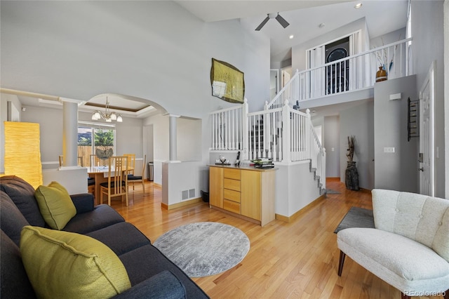 15157 E Nassau Ave, Aurora, CO 80014 - living area with ornate columns, stairway, a high ceiling, light wood-type flooring, and a chandelier