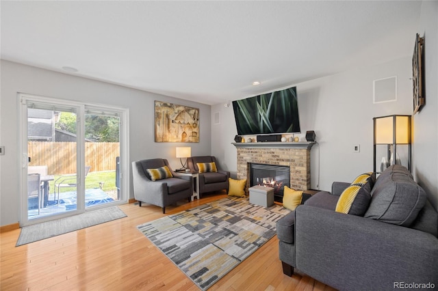 15157 E Nassau Ave, Aurora, CO 80014 - living room featuring light wood-style flooring and a brick fireplace