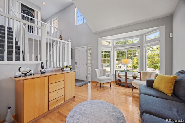 15157 E Nassau Ave, Aurora, CO 80014 - living area with stairs, plenty of natural light, a towering ceiling, and light wood-type flooring