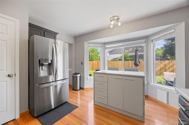15157 E Nassau Ave, Aurora, CO 80014 - kitchen featuring stainless steel refrigerator with ice dispenser, healthy amount of natural light, light countertops, and light wood-style floors