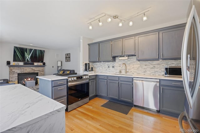 15157 E Nassau Ave, Aurora, CO 80014 - kitchen with stainless steel appliances, a peninsula, open floor plan, tasteful backsplash, and gray cabinetry