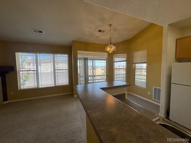 kitchen featuring freestanding refrigerator, visible vents, and baseboards