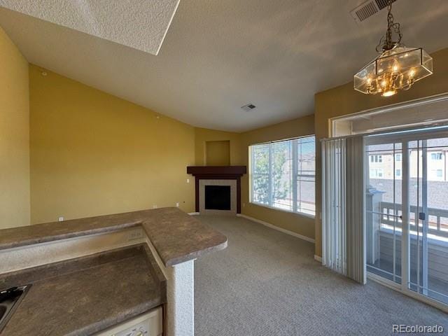 unfurnished living room with a fireplace with flush hearth, lofted ceiling, light colored carpet, and plenty of natural light