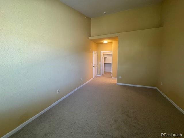 carpeted empty room with baseboards