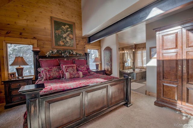 bedroom featuring ensuite bath, wooden walls, and light carpet