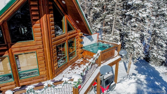 view of snow covered exterior featuring a hot tub