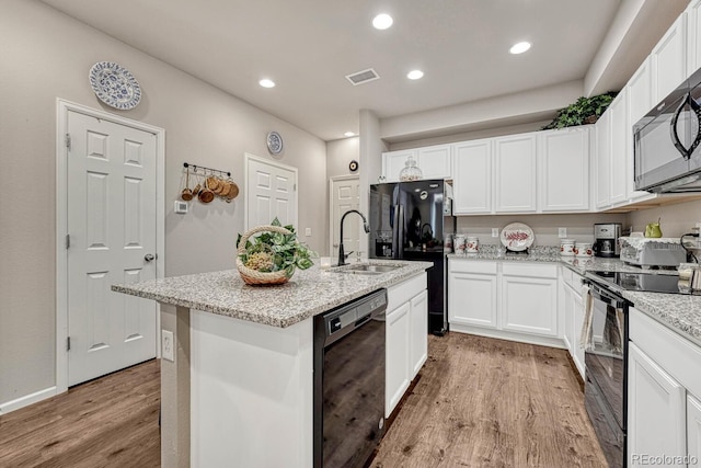 kitchen featuring light hardwood / wood-style floors, black appliances, sink, an island with sink, and white cabinets