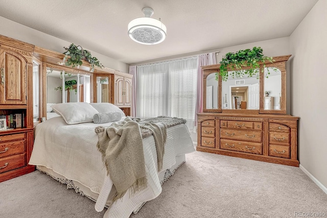 bedroom with a textured ceiling and light carpet