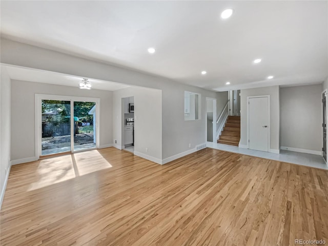 unfurnished living room featuring light hardwood / wood-style floors and a notable chandelier