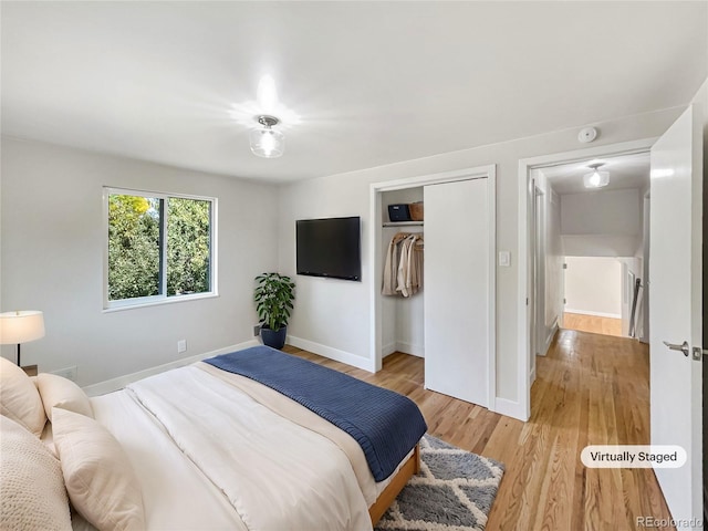 bedroom with light hardwood / wood-style floors and a closet