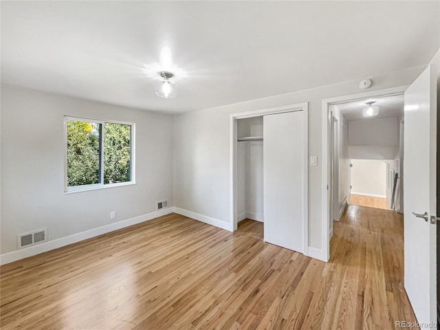 unfurnished bedroom featuring light hardwood / wood-style flooring and a closet