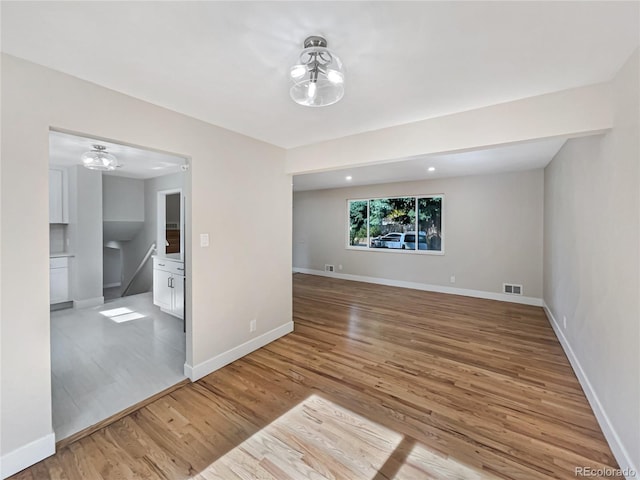 unfurnished room with light hardwood / wood-style flooring and a notable chandelier