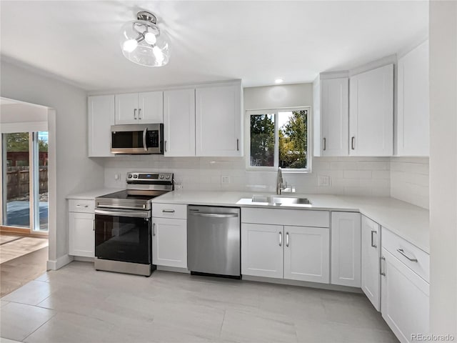 kitchen featuring sink, appliances with stainless steel finishes, white cabinetry, and plenty of natural light